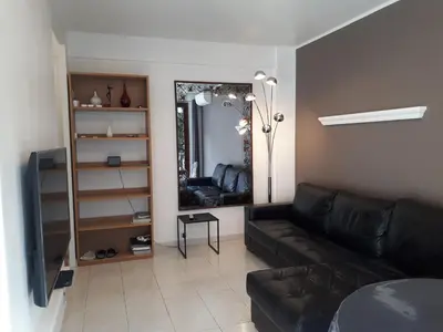 a living room with a couch and a mirror at Appart bas Fabron in Nice