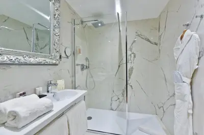 a bathroom with a shower and a sink and a mirror at Hotel La Villa Nice Promenade in Nice