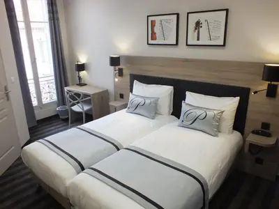 two beds in a hotel room with two silver wedding pillows at Hotel Paganini in Nice