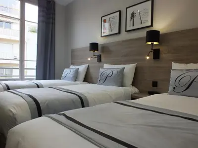 a group of three beds in a hotel room at Hotel Paganini in Nice