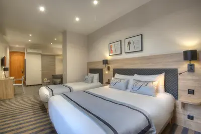a hotel room with two beds in a room at Hotel Paganini in Nice