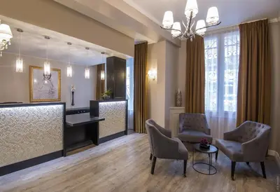 a salon with chairs and a desk and a mirror at Hotel Paganini in Nice