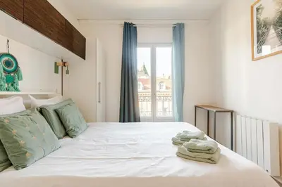 a bedroom with a white bed with towels on it at Homelivia Av Jean Médecin in Nice