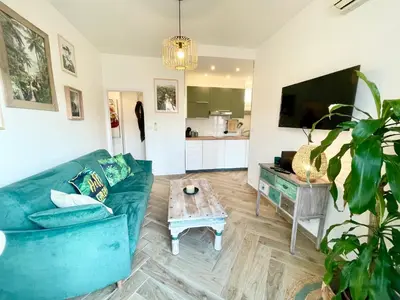 a living room with a blue couch and a table at Homelivia Av Jean Médecin in Nice