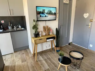 a living room with a table and a tv on a wall at Homelivia Av Jean Médecin in Nice