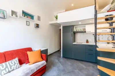 a living room with a red couch and a kitchen at Homelivia Av Jean Médecin in Nice