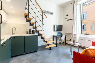a living room with a staircase and a table at Homelivia Av Jean Médecin in Nice