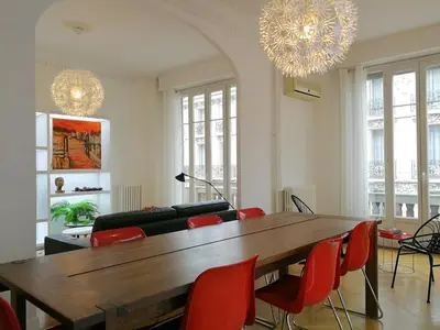 a living room with a wooden table and red chairs at Le Maréchal in Nice