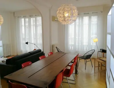 a dining room with a wooden table and a chandelier at Le Maréchal in Nice