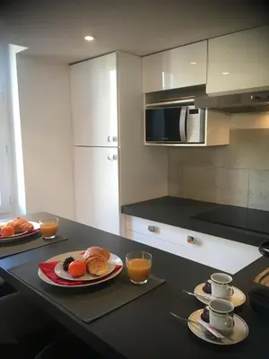 two cups on plates next to a coffee maker at Charme Méditerranéen Votre pied à terre au Cœur du Port de Nice in Nice