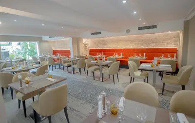a restaurant with tables and chairs in a room at Hotel Lou Castelet in Carros