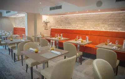 a restaurant with tables and chairs in a room at Hotel Lou Castelet in Carros