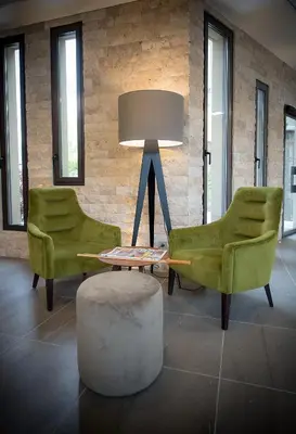 two chairs and a table and a lamp in a room at Hotel Lou Castelet in Carros