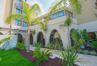 a building with palm trees in front of it at Hotel Lou Castelet in Carros