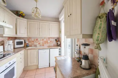a kitchen with white cabinets and a blender on a counter at Appartement Lanterne Welkeys in Nice
