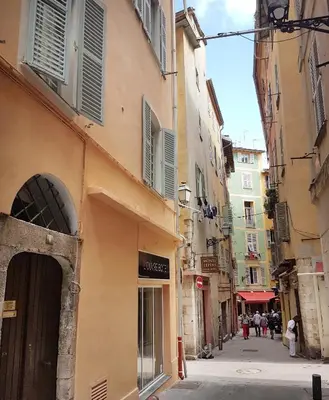 an alley with buildings and people walking down a street at Family Apartment 2BR Old Town near Beach AC in Nice
