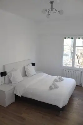 a white bedroom with a bed and a window at Nice Plein Centre, Calme et Proche de la mer in Nice
