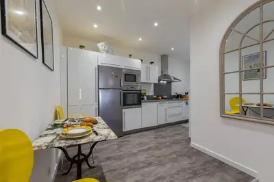 a kitchen with a table and a refrigerator at BARILLERIE - Loft Moderne, Face Mer, Vieux-Nice. in Nice