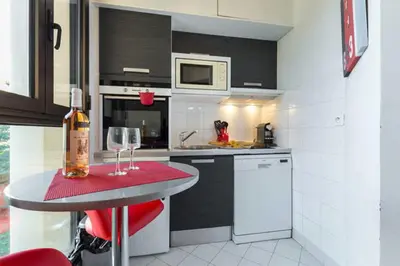 a kitchen with a table with wine glasses on it at GRAND H -F2, FACE VIEUX- NICE, TERRASSE, ASCENSEUR, CLIMATISATION, Terrace - Nice city center in Nice