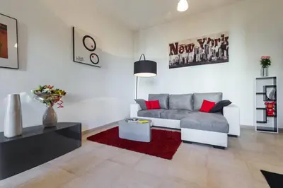 a living room with a grey couch and red pillows at GRAND H -F2, FACE VIEUX- NICE, TERRASSE, ASCENSEUR, CLIMATISATION, Terrace - Nice city center in Nice