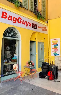 a yellow building with chairs and a table in front of a store at GRAND H -F2, FACE VIEUX- NICE, TERRASSE, ASCENSEUR, CLIMATISATION, Terrace - Nice city center in Nice