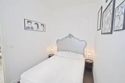 a white bed in a room with pictures on the wall at PROMENADE HOLIDAY - PALATIN & SEA in Nice