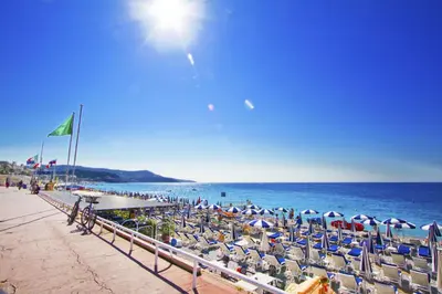 a group of chairs and umbrellas on a beach at PROMENADE HOLIDAY - PALATIN & SEA in Nice