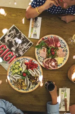 a wooden table with plates of food on it at Hotel Restaurant Isidore by Soniho in Nice