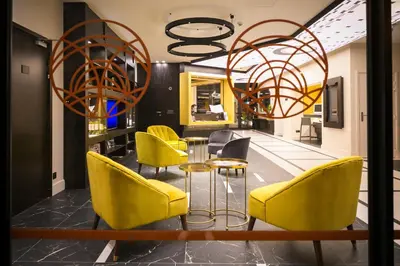 a dining room with yellow chairs and a table at Best Western Hôtel Journel Saint-Laurent-du-Var Aéroport in Saint-Laurent-du-Var