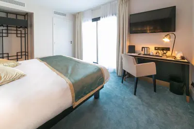 a hotel room with a bed and a desk at Best Western Hôtel Journel Saint-Laurent-du-Var Aéroport in Saint-Laurent-du-Var