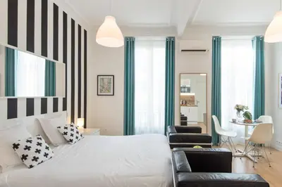 a bedroom with a white bed with black and white stripes at Le Studio Graphite Welkeys in Nice