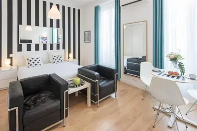 a bedroom with a bed and a table and chairs at Le Studio Graphite Welkeys in Nice