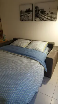 a bed with blue sheets and pillows on it at Nice France in Nice