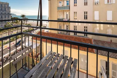 a wooden bench sitting on top of a balcony at Prestige Apartment, near the beaches in Nice