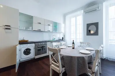 a kitchen with a table with chairs and a kitchen with a washing machine at Prestige Apartment, near the beaches in Nice