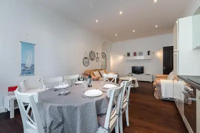 a dining room and living room with a table and chairs at Prestige Apartment, near the beaches in Nice