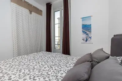 a bedroom with a bed and a window at Prestige Apartment, near the beaches in Nice