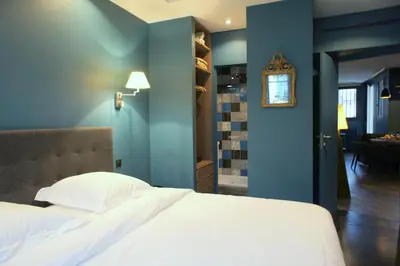 a bedroom with a white bed and a blue wall at Ze Perfect Place - Élégant appartement avec terrasse - Promenade des Arts in Nice