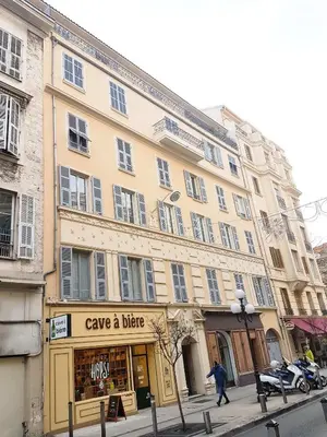 a large building on a city street with a man walking past it at Ze Perfect Place - Élégant appartement avec terrasse - Promenade des Arts in Nice