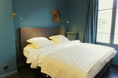 a bedroom with a large white bed with a window at Ze Perfect Place - Élégant appartement avec terrasse - Promenade des Arts in Nice