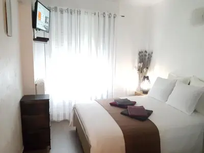 a bedroom with a large bed with a large window at Les Pieds dans l'Eau in Nice