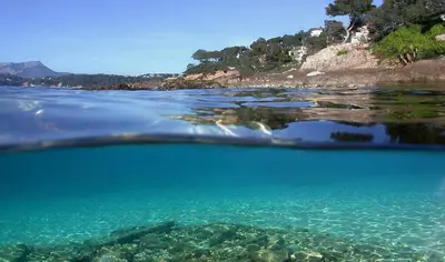 a view of a beach with boats in the water at Les Pieds dans l'Eau in Nice