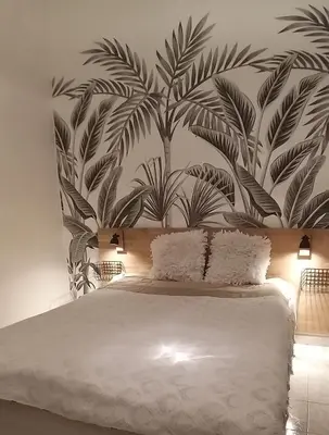 a bedroom with a large bed with a mural of leaves at Les Grands Cedres D3 in Nice