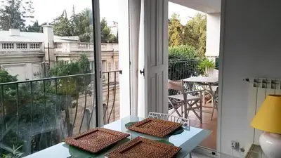 a room with a balcony with a table and chairs at Les Grands Cedres D3 in Nice