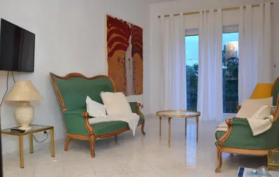 a living room with chairs and a table and windows at Les Grands Cedres D3 in Nice