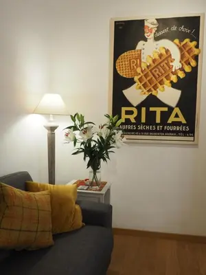 a living room with a couch and a poster on the wall at 2 Bedroom Apartment Old Town Centre in Nice