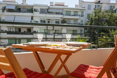 a wooden table with plates and glasses on a balcony at le capitole in Nice