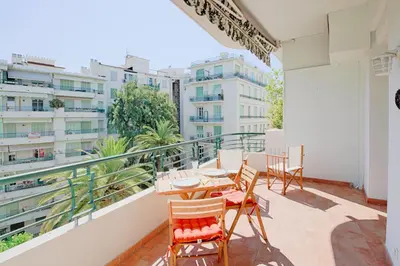 a balcony with a table and chairs and buildings at le capitole in Nice