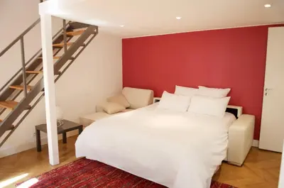 a bedroom with a white bed and a red wall at AzurAppart Elegant Studio Centre in Nice