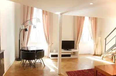 a living room with a table and a television at AzurAppart Elegant Studio Centre in Nice